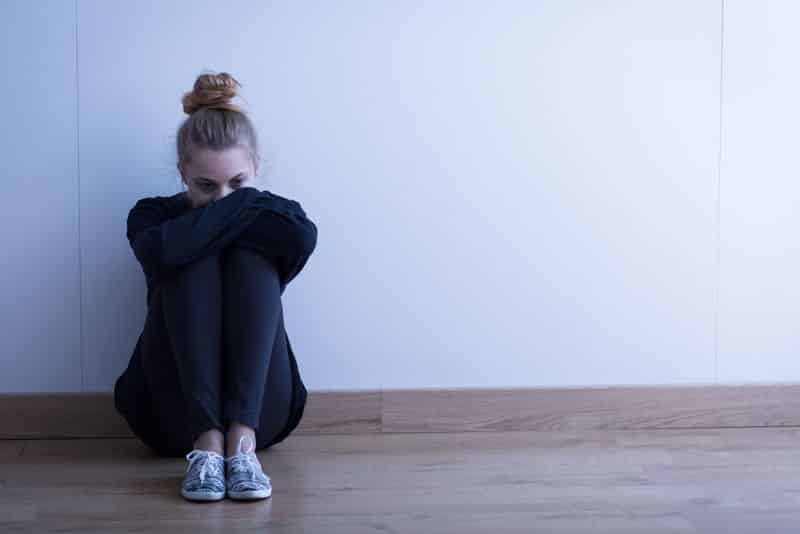 sad woman with depression sitting on the floor